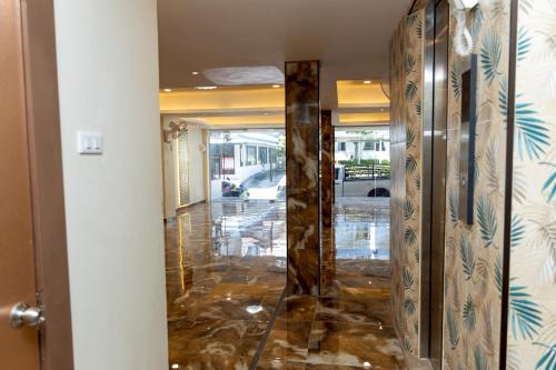 a hallway with a glass door and marble floor at Sea Inn Pattaya in Pattaya Central
