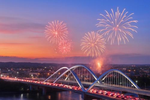 a bridge with fireworks over a river with traffic at Gold Coast PIK Apartments by Host Jess in Jakarta