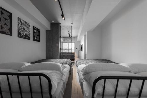 three beds in a room with white walls at Luxia 601 in Sapporo