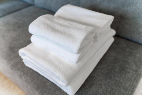 a pile of white towels sitting on a couch at Luxia 601 in Sapporo