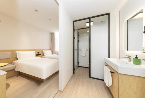 a hotel room with a bed and a bathroom at Hi Inn Beijing Olympic Park in Beijing