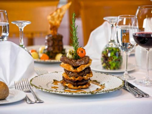 a plate of food on a table with wine glasses at Hotel Grand Kaptan - Ultra All Inclusive in Alanya