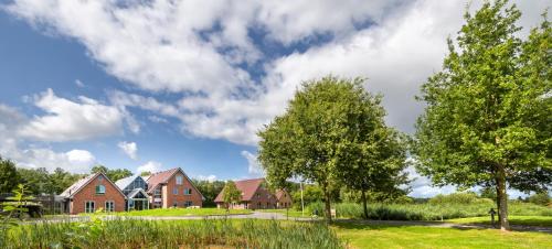 a group of houses in a field with trees at ESSTRA Hotel Erica in Erica