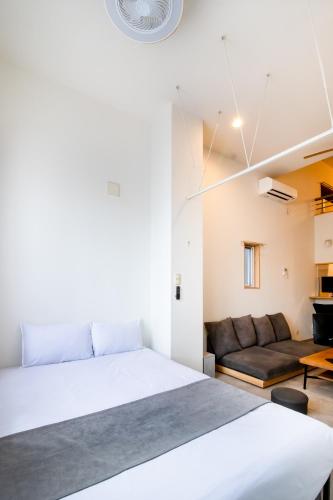 a bedroom with a large bed and a couch at STAIRS Hotel 402 in Fukuoka