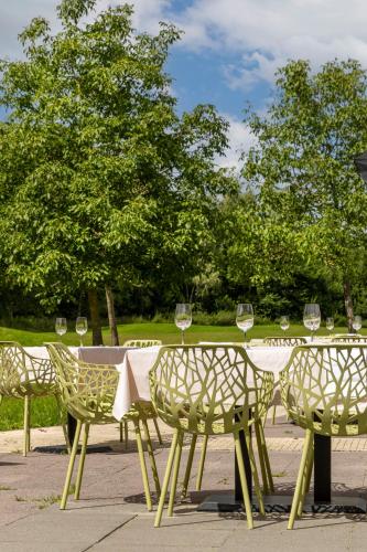 a table and chairs with wine glasses on it at ESSTRA Hotel Erica in Erica