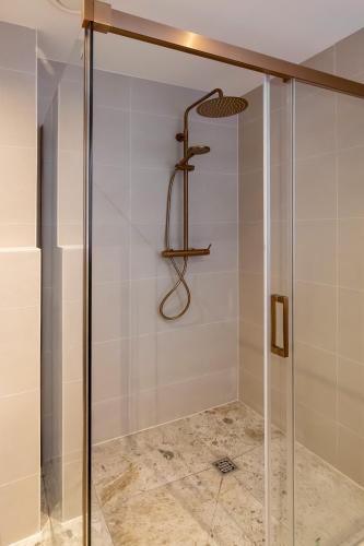 a shower with a glass door in a bathroom at ESSTRA Hotel Erica in Erica
