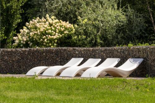 a row of white chairs sitting in the grass at ESSTRA Hotel Erica in Erica