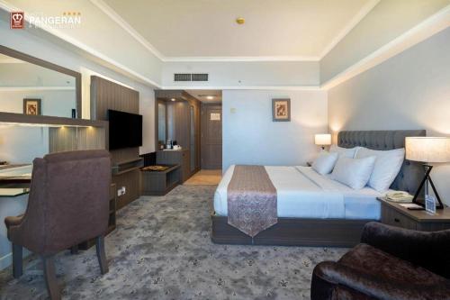 a large hotel room with a bed and a desk at Hotel Pangeran in Pekanbaru