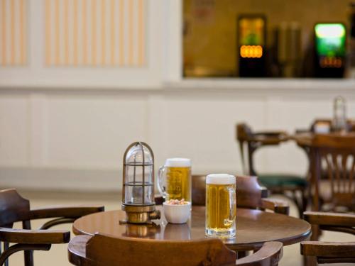 two glasses of beer and a bird cage on a table at Hotel Grand Kaptan - Ultra All Inclusive in Alanya