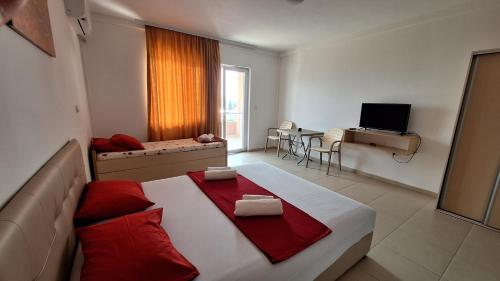 a bedroom with a large bed with red pillows on it at Vila Stefan in Star Dojran