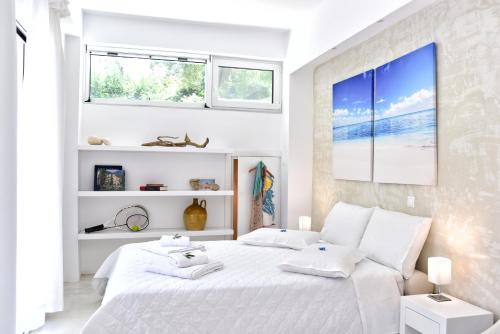a white bedroom with a large bed with towels on it at Mavres Luxury Studio in Ágios Matthaíos