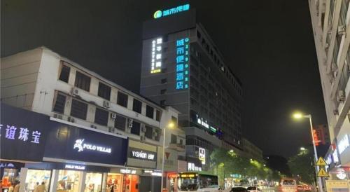 a tall building with blue lights on it at night at City Comfort Inn Zhaoqing Qixingyan Scenic Area Xinghu Archway in Zhaoqing