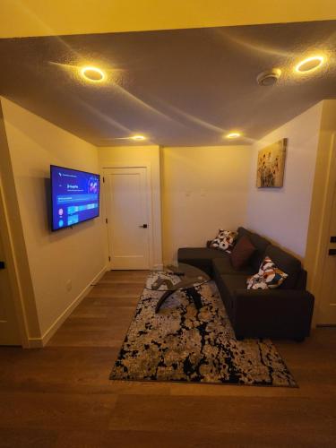a living room with a couch and a flat screen tv at Home in Calgary in Calgary