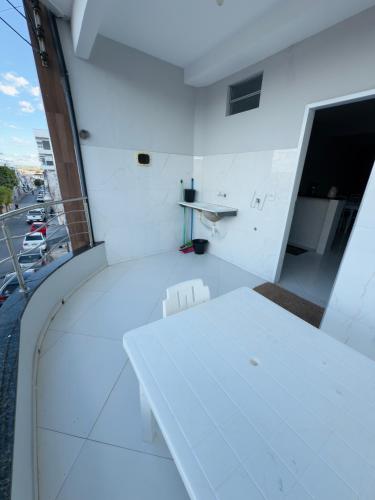 a white table and chairs in a room with a street at Serra Flat in Tianguá