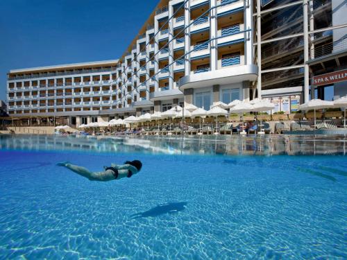 a person swimming in a swimming pool with a shark in the water at Hotel Grand Kaptan - Ultra All Inclusive in Alanya