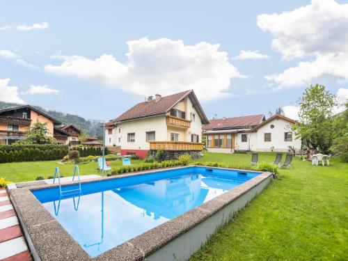 a backyard with a swimming pool and a house at Apartment in Tröpolach near Nassfeld in Tröpolach