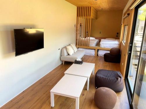a living room with a couch and a tv at 佐渡風流 nagomi in Sado