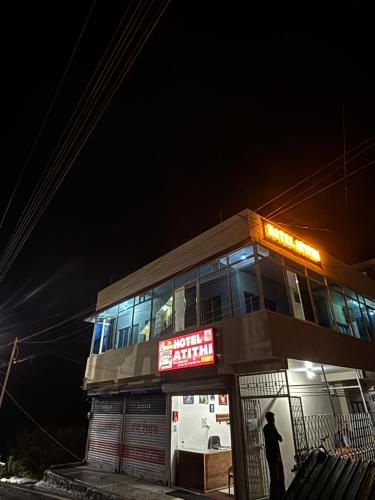 a man standing outside of a building at night at Hotel Atithi in Joshīmath