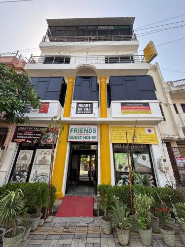 a yellow and white building with a store at Friends Guest House & Hostel- near TAJ MAHAL in Agra