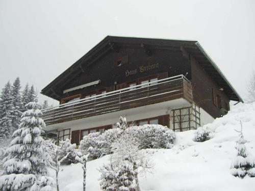 un edificio cubierto de nieve con árboles delante en Chalet in Vorarlberg near Ski Slopes, en Egg