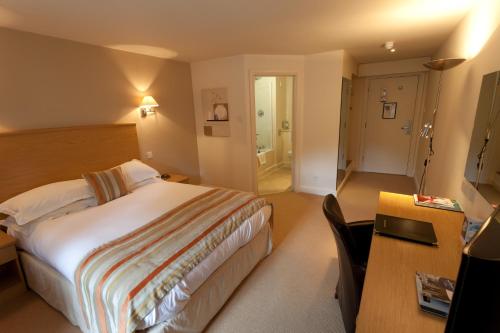 a hotel room with a bed and a desk and a table at Best Western Plus Sheffield Mosborough Hall Hotel in Sheffield