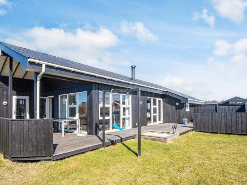 a house with a deck and a fence at 6 person holiday home in Hirtshals-By Traum in Hirtshals