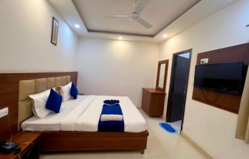a bedroom with a bed and a flat screen tv at Hotel Royal aroma by Shradha Residency in Rāiwāla