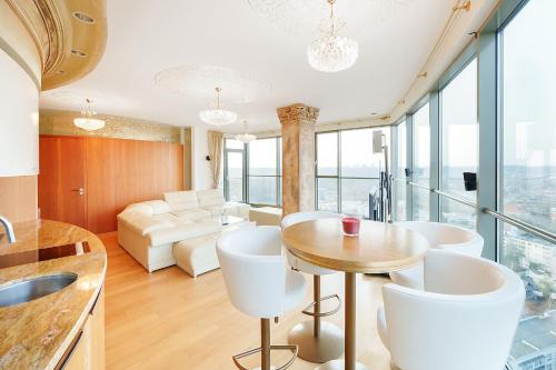 Una cocina y una sala de estar con mesa y sillas. en Helios city nice view apartment 20 and 11 floor double, en Vilna