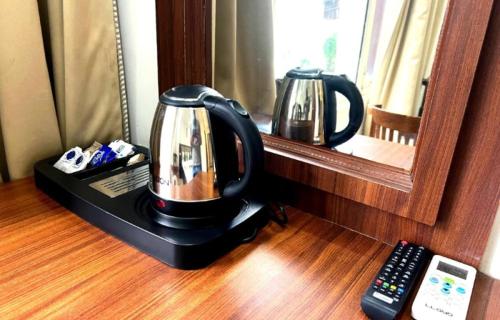 a coffee maker sitting on a table in front of a mirror at Hotel Royal aroma by Shradha Residency in Rāiwāla