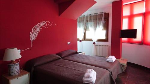 a bedroom with a red wall with a bed at Zendoira in Palas de Rei 