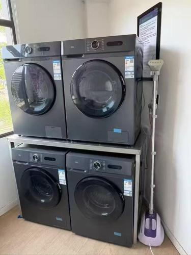 three washing machines are stacked on top of each other at 康铂酒店深圳国际会展中心店 in Shenzhen