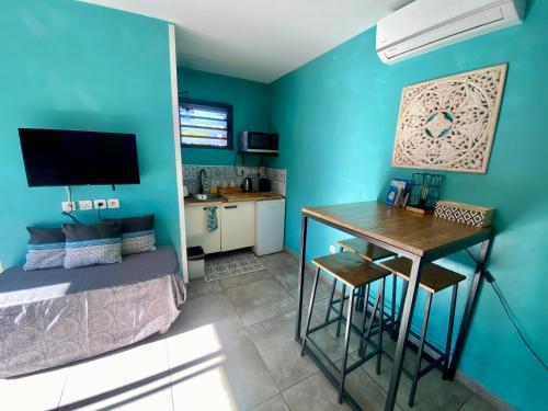 una camera da letto con pareti blu, scrivania e letto di La plénitude - Dar Sakina a Saint-Pierre