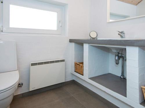 a bathroom with a toilet and a sink and a window at 8 person holiday home in Glesborg in Glesborg