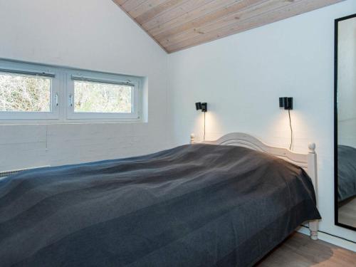 a bedroom with a bed and two windows at 8 person holiday home in Glesborg in Glesborg