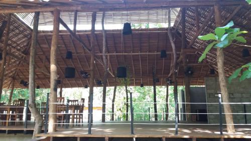 an open area with a large room with trees at Kottawatta Village in Udawalawe