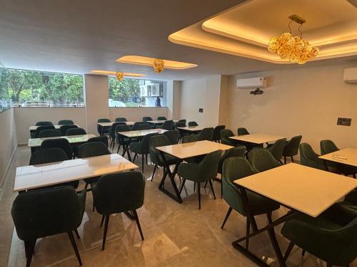a classroom with tables and chairs in a room at Leaf 9 Grand, Near Udyog vihar and Yashobhoomi in Gurgaon
