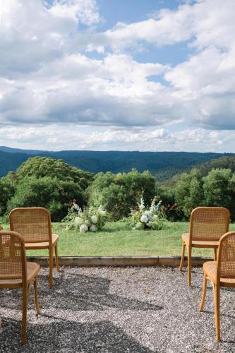 a group of chairs sitting on a patio with a view at Luxurious Mountain Retreat near Maleny in Booroobin