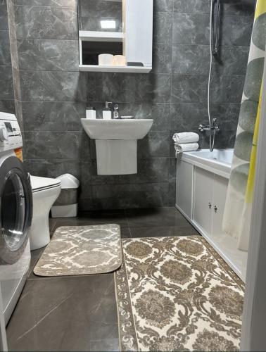a bathroom with a sink and a washing machine at Квартира-студия in Bilhorod-Dnistrovsʼkyy
