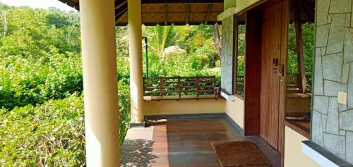 a porch of a house with a view at Niraamaya Wellness Retreats, Surya Samudra, Kovalam in Kovalam