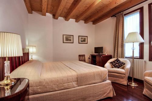 a bedroom with a bed and a desk and a chair at Villa Dacri in Venice-Lido