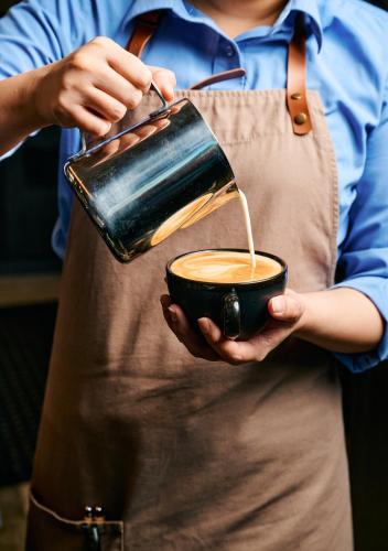 a person is holding a cup of coffee at Oakwood Premier Melbourne in Melbourne