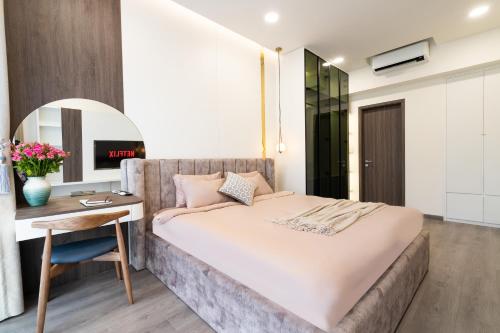 ein Schlafzimmer mit einem Bett, einem Schreibtisch und einem Stuhl in der Unterkunft Luxury 3BR Apartment 121m - Resort Pool & Gym - Near Aeon Mall in Ho-Chi-Minh-Stadt