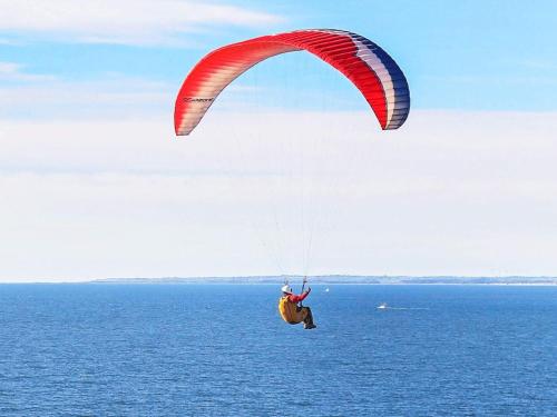 a person riding a parachute over the ocean at 7 person holiday home in Struer-By Traum in Humlum