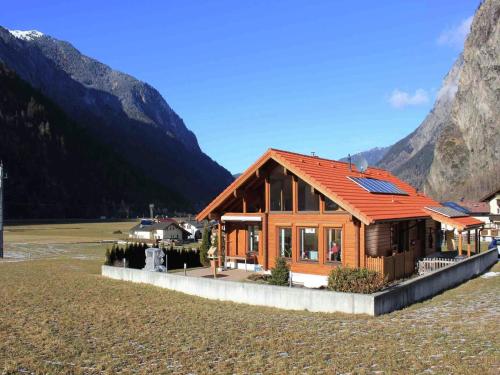 a house in a field with mountains in the background at Chalet in Ötztal near Ötz-Hochötz Ski Resort in Umhausen