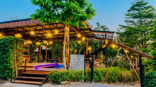 a house with a wooden structure with lights at Heaven Hill Camping in Ban Thung Na