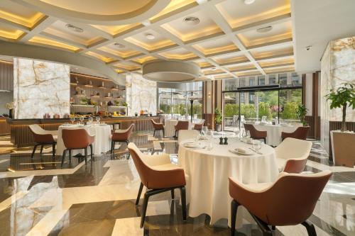 um restaurante com mesas, cadeiras e um bar em Mileo Hotel The Palm no Dubai