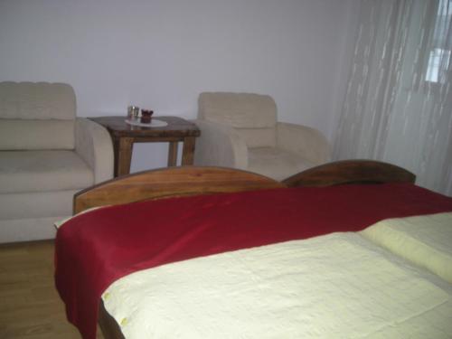 a living room with a bed and a couch and chairs at Turistična Kmetija Logar in Grahovo