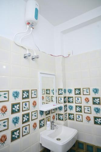 a bathroom with a sink and a mirror at Sai Padma Guest House in Konārka
