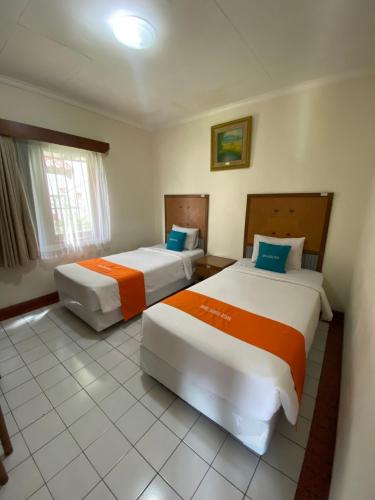 two beds in a hotel room with two bedsvisor at Sangga Buana Resort & Convention Hotel in Pacet