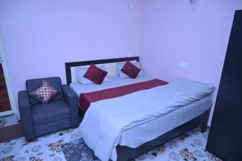 a bedroom with a bed and a chair at Sai Padma Guest House in Konārka